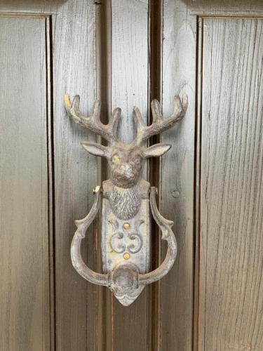 a door knocker of a deer with antlers on a door at Csonkás Kúria Vendégház Zemplén in Mogyoróska