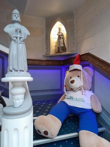 a teddy bear wearing a santa hat sitting in a room at Brit Hotel Comtes De Champagne - Troyes Centre Historique in Troyes