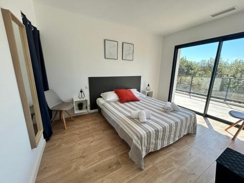 une chambre avec un lit et une grande fenêtre dans l'établissement Casacilagna, à Zonza