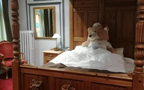 a stuffed teddy bear sitting in a bed at Brit Hotel Comtes De Champagne - Troyes Centre Historique in Troyes