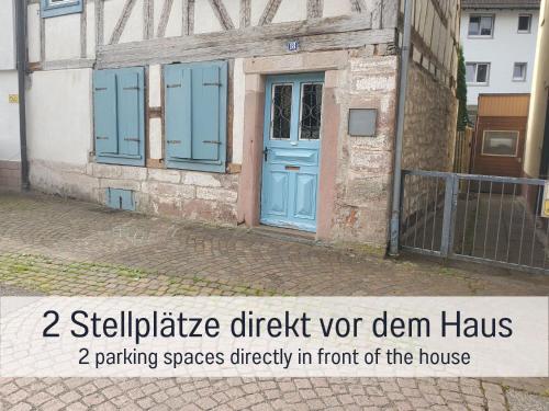 a building with a blue door and the words sustainable brick nor den haus at Historisches Gerberhaus in Alpirsbach