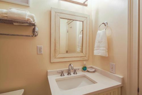 基洼岛Palm Bungalow的浴室里有白色洗手池和镜子