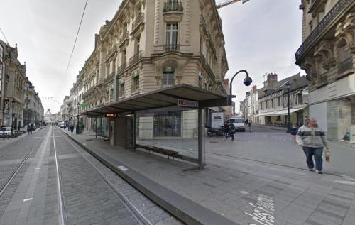 une femme marchant dans une rue de la ville avec un bâtiment dans l'établissement Studio 8 rue de la République, à Orléans