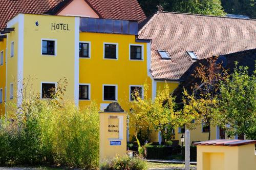 a yellow building with a hotel sign in front of it at Hotel Schlossresidenz Heitzenhofen in Duggendorf