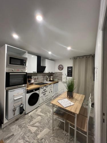 une cuisine avec des appareils en acier inoxydable et une table en bois dans l'établissement L'Évidence, à Saint-Raphaël