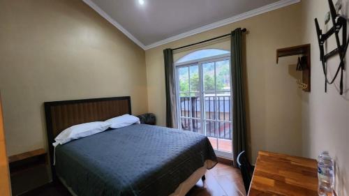 a bedroom with a bed and a large window at Grand Tactic Hotel in Tampoc