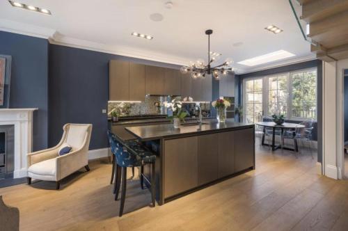 a kitchen and living room with a table and chairs at Luxury 4 Bedrooms 5 Baths 2 Receptions Family House with Garden Chelsea in London