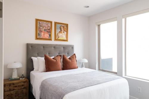 a white bedroom with a large bed with pillows at Vogue Posh Pad - Center of LoHi - Large Roof Deck in Denver