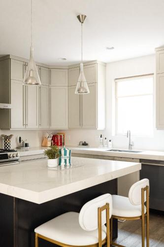 a kitchen with white cabinets and a large island with stools at Vogue Posh Pad - Center of LoHi - Large Roof Deck in Denver