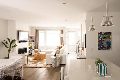 a white living room with a white couch and a table at Vogue Posh Pad - Center of LoHi - Large Roof Deck in Denver