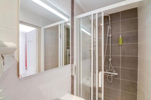 a bathroom with a shower and a mirror at Brit Hotel Comtes De Champagne - Troyes Centre Historique in Troyes