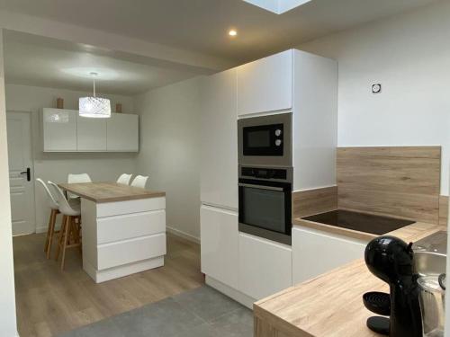 a kitchen with white cabinets and a counter top at Maison idéale pour vos vacances in Faches-Thumesnil