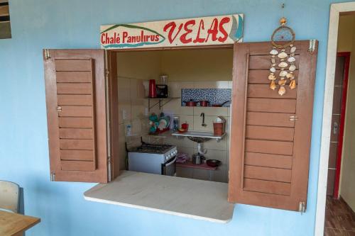 a kitchen with an open door to a small kitchen at Chalés Panulirus in Icapuí