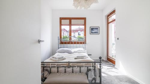a bed in a white room with a window at Prestige Apartments Neptun Park in Gdańsk