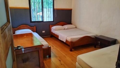 a small room with two beds and a window at Finca Turística Peñoles - Cerca de Charcos y Cascadas - Finca Rústica en San Carlos, Antioquia in San Carlos