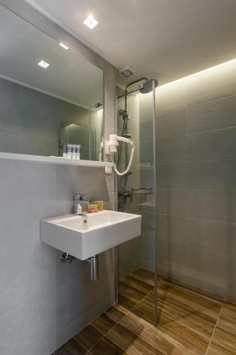 a bathroom with a white sink and a mirror at Marialena Hotel in Flogita