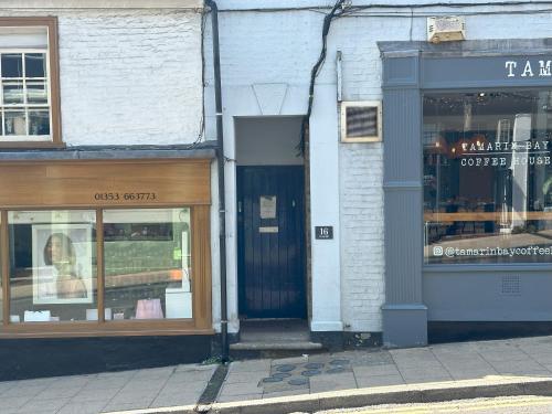 a store front with the door open on a street at Ely Stays Flat 1 in Ely