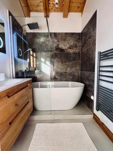 une salle de bain avec une baignoire blanche et un lavabo dans l'établissement Alpine Retreat with Mont Blanc View, Chamonix, private parking, à Chamonix-Mont-Blanc