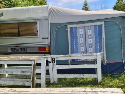 an rv with a tent sitting in the grass at Camping - Park Władysławowo in Władysławowo