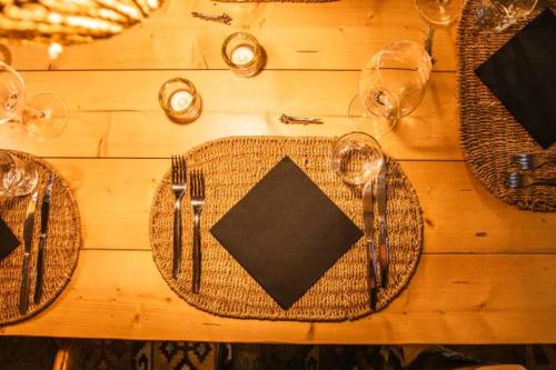 a wooden table with plates and utensils on it at Patatouc Country House - 15 minuti di cammino da Limonetto in Limone Piemonte
