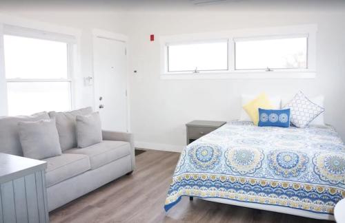 トゥルーロにあるFresh and Crisp Pet Friendly Studioのベッドとソファのある白い寝室