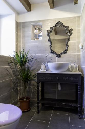 une salle de bain avec un lavabo et un miroir dans l'établissement Petite Maison de Mouton, à Azat-le-Riz