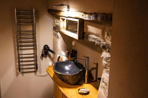 a bathroom with a sink with a stone wall at Patatouc Country House - 15 minuti di cammino da Limonetto in Limone Piemonte