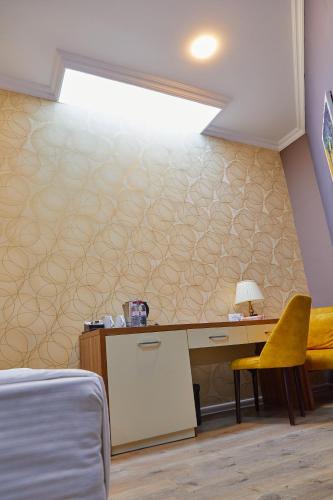 a bedroom with a bed and a desk with a lamp at Square Boutique Hotel in Baku