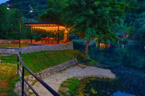 a gazebo sitting next to a lake at night at Holiday Homes Mujo Bejzin in Račić