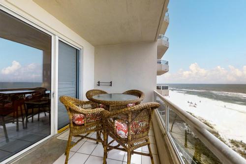 a balcony with a table and chairs and the ocean at The Enclave 606 in Orange Beach