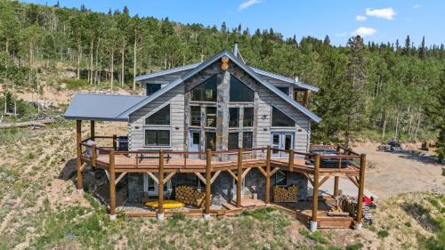 a house on a hill with a large deck at Custom 2BR & Loft Home, with Hot Tub & Stunning Views in Alma