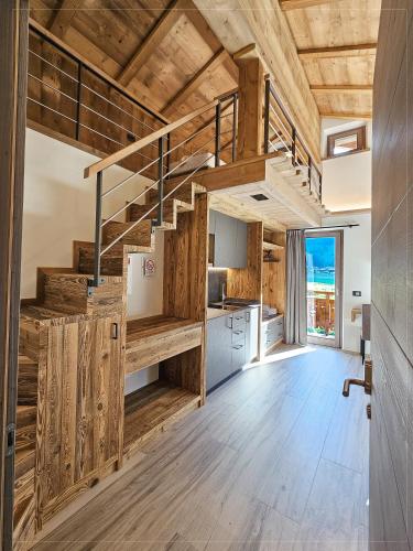 a kitchen with wooden walls and wooden stairs in a house at Agriturismo Bosco d'oro Livigno in Livigno