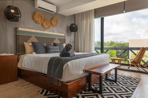 a bedroom with a large bed and a balcony at Unwind | Private Balcony & Rooftop Pools | Casago in Tulum