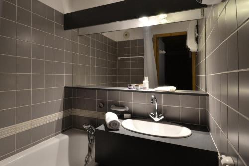 une salle de bain avec un lavabo, un miroir et une baignoire dans l'établissement Résidence Carene - 2 Pièces pour 5 Personnes 79, à Mâcot La Plagne