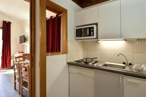 une cuisine avec un évier et un micro-ondes dans l'établissement Résidence Carene - 2 Pièces pour 5 Personnes 79, à Mâcot La Plagne