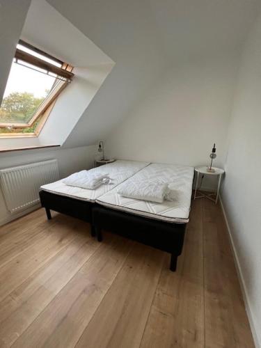 a bedroom with a bed in a room with a window at Kragenæs Havn in Torrig