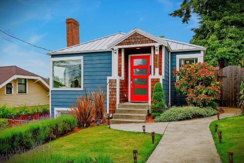 a blue house with a red door in a yard at Blue Oasis with Amazing Olympic Views in Seattle