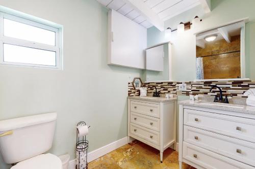 a bathroom with a sink and a toilet and a window at Key Colony Hide Away in Key Colony Beach