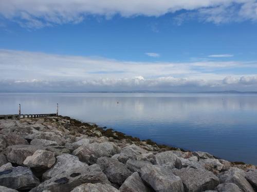 a large group of rocks on a body of water at Olivia Cottage - a Home From Home by the Sea in Morecambe
