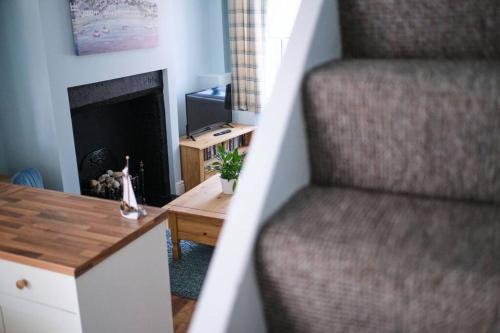 a living room with a staircase with a fireplace at Olivia Cottage - a Home From Home by the Sea in Morecambe