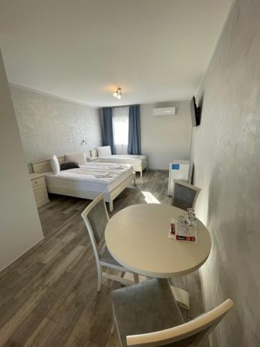 a room with a bed and a table and a couch at Airport Wanderer Inn - Vándor fogadó in Vecsés