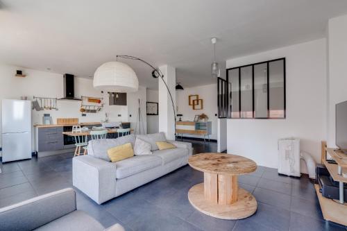 un salon et une cuisine avec un canapé et une table dans l'établissement Le Panoramique - Ramblas Jean-Jaurès, à Toulouse