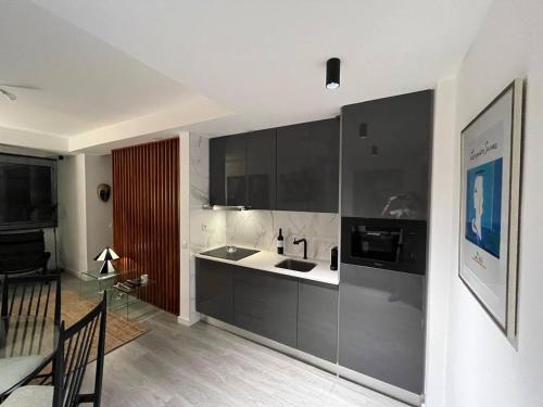 a kitchen with black and white cabinets and a table at comfortavel in Figueira da Foz