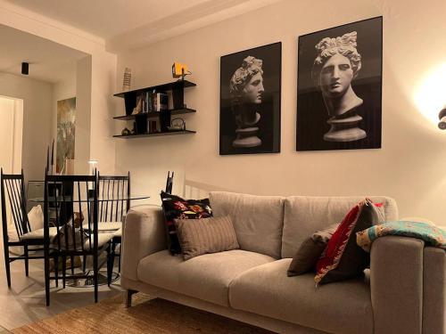a living room with a couch and pictures on the wall at comfortavel in Figueira da Foz