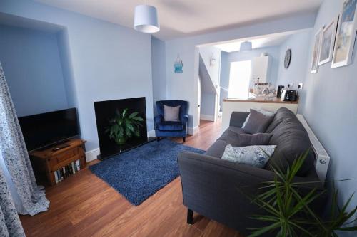a living room with a couch and a tv at Evie Cottage - The peaceful Retreat in Morecambe