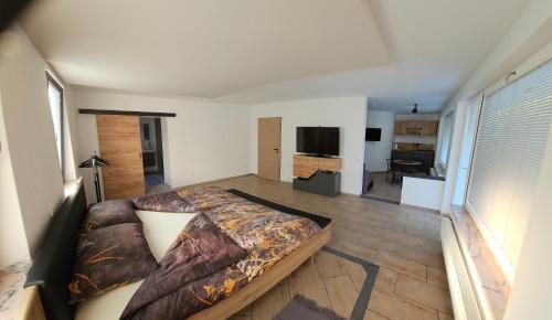 Un dormitorio con una cama grande y una sala de estar. en Grmač Apartments, en Naklo