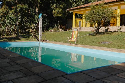 MajéにあるOtima Casa de campo com churrasq e WiFi em Mage RJの家の隣にあるスイミングプール(椅子付)