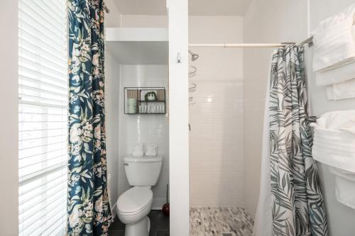 a bathroom with a toilet and a shower curtain at The Speakeasy Inn and Rum Bar in Key West