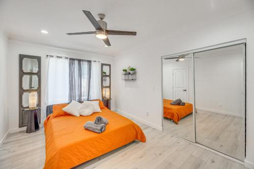 ロサンゼルスにあるEast Los Angeles Retreat about 2 Mi to Citadel Outletsのベッドルーム(オレンジ色のベッド1台、鏡付)