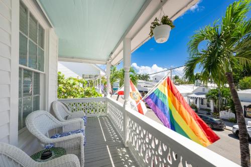 a porch with chairs and a colorful umbrella at The Speakeasy Inn and Rum Bar in Key West